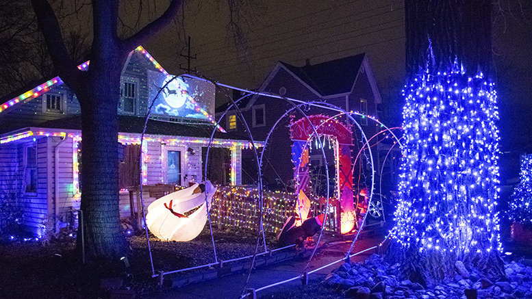 This home in the 700 block of West 11th Street has a lot going on within it including Santa and his sleigh projected on a screen from the 2nd story. Photo by Mike Rhodes
